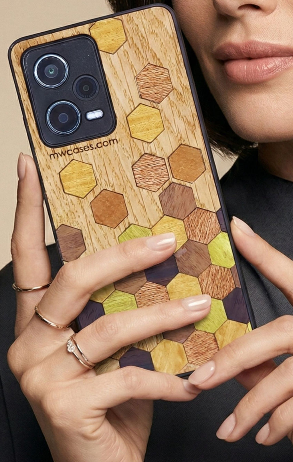 wooden marquetry phone case with hexagon motiv in hand of a woman with rings on fingers