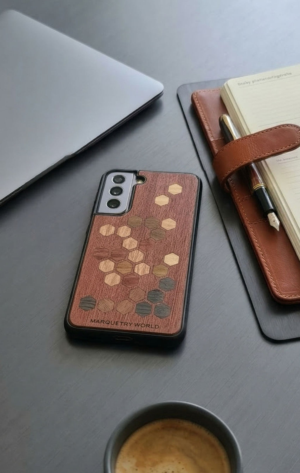 wooden marquetry phone case with hexagon motiv on table next to notes
